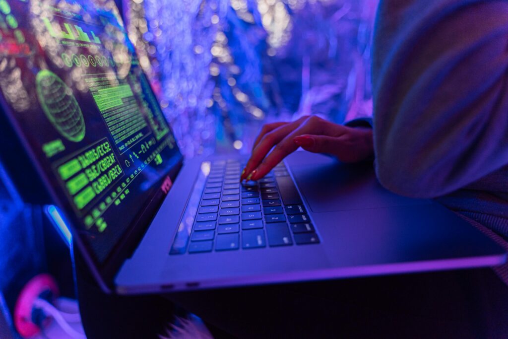 How to Recover Hacked Accounts: Essential Skills for Digital Life in 2025 Close-up of hands typing on a laptop displaying cybersecurity graphics, illuminated by purple light.